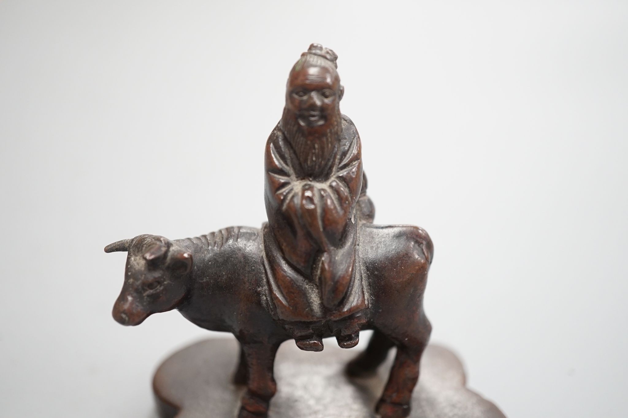 A small Chinese bronze seal of an immortal riding a bull and a Tibetan prayer case 9cm